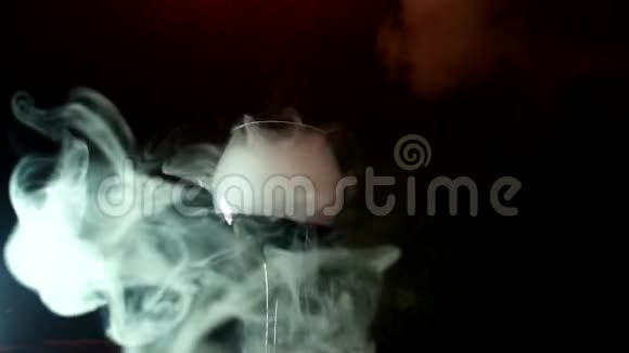 干冰效果酒玻璃在黑色背景上溢出蒸汽烟雾在玻璃棒上翻腾视频的预览图