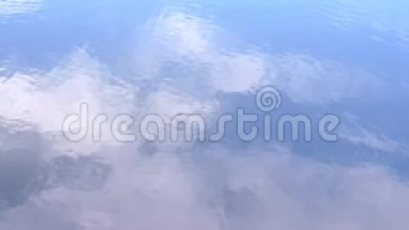 抽象的背景水反射天空中的云枝和水面上的树木视频的预览图