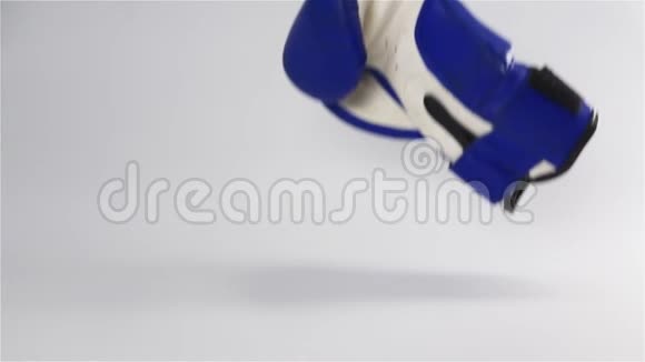 老式深蓝色拳击手套掉落在白色表面和弹跳视频的预览图