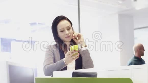 办公室里的女人在检查手机视频的预览图
