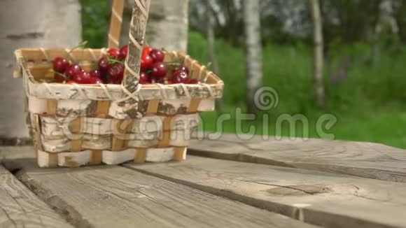 一篮子成熟的樱桃落在木桌上视频的预览图