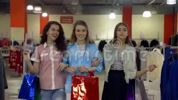 三个兴高采烈的年轻女人穿着五颜六色的衣服穿过一家百货公司视频的预览图