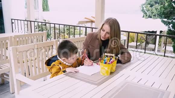 妈妈和小男孩在桌子上用蜡笔画画视频的预览图