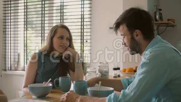 两个年轻的父母在厨房的餐桌上交谈而他们的女儿正在着色慢点斯泰迪达姆视频的预览图