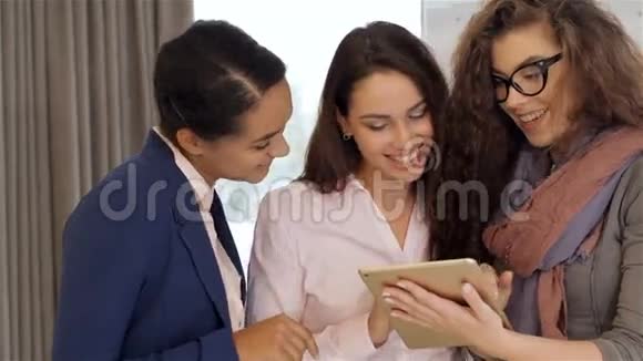 三个女人在办公室看着平板电脑视频的预览图