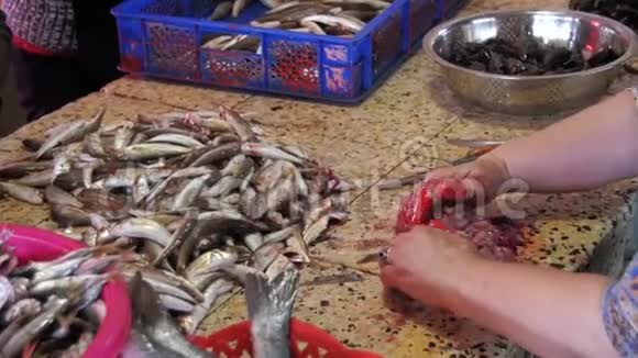 女小贩在鱼市里切鱼慢动作视频的预览图