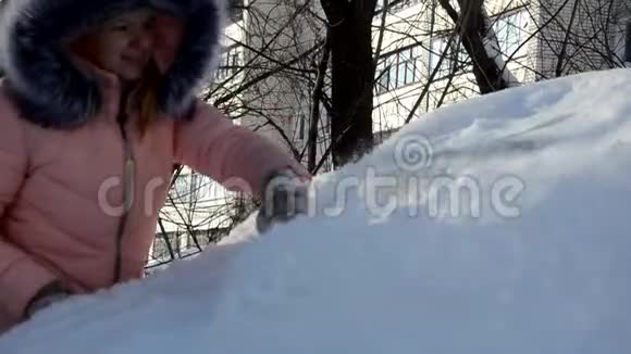 一个年轻女人从车里擦雪的冬天画像美女金发模特女孩笑着兴高采烈地打扫卫生视频的预览图