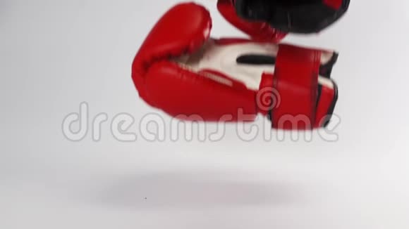 红皮拳击手套的一对脚掉下来并在白色上分开反弹视频的预览图