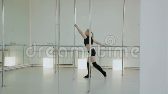 女钢管舞女女舞女在演播室里在塔台上跳舞视频的预览图