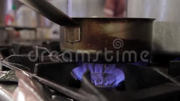 在煤气炉上在一个大火上有一个带手柄的脏水包视频的预览图