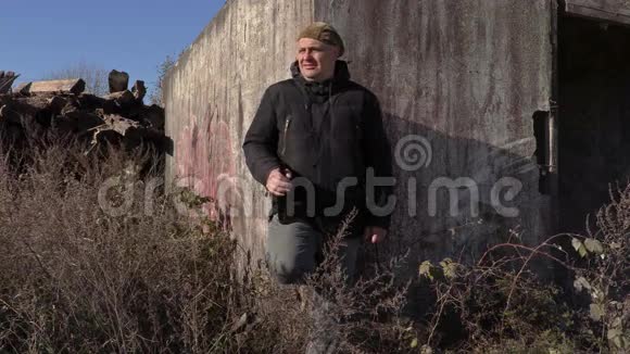 在废弃建筑附近带着酒瓶的沮丧的男人视频的预览图