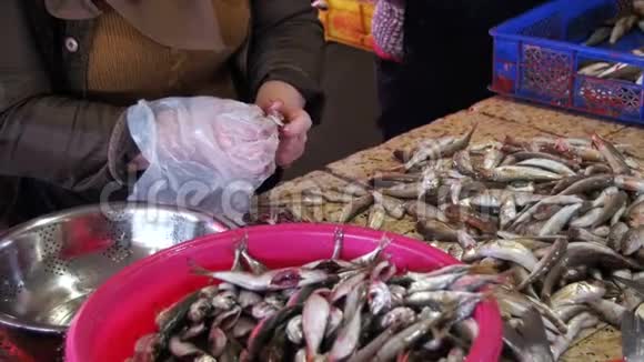 女小贩在鱼市里切鱼慢动作视频的预览图