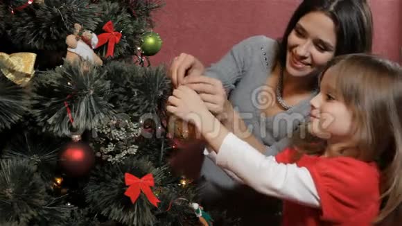 妈妈帮女儿把宝布尔挂在圣诞树上视频的预览图