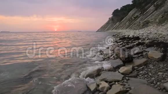 特写慢动作低宽角度小海浪在岩石海滩上翻滚沿着海滩向前移动海滨视频的预览图