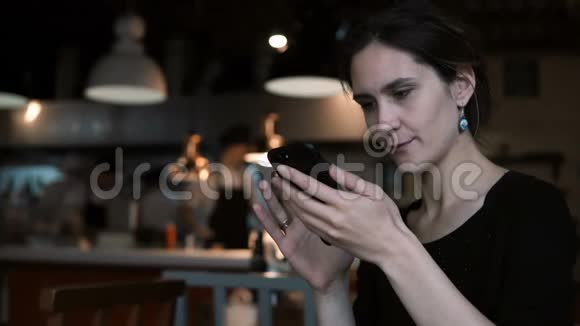 漂亮的年轻女人坐在咖啡馆里使用智能手机有吸引力的女性打字信息在触摸屏上视频的预览图