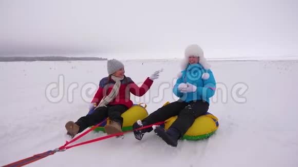 幸福家庭的概念孩子和母亲在冬天雪橇妈妈和女儿在圣诞节假期玩视频的预览图