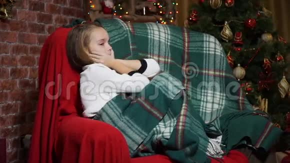 小女孩在圣诞树附近的椅子上调情视频的预览图