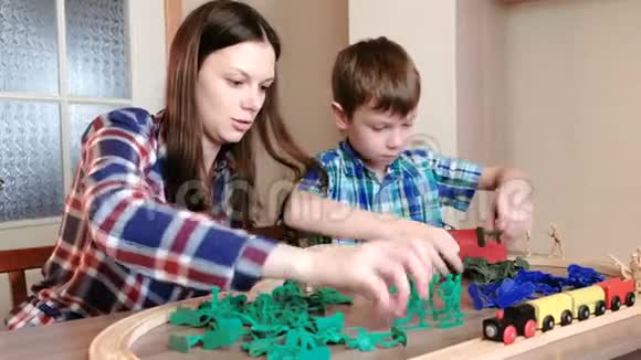 一起玩妈妈和儿子正在玩一条木制铁路火车马车和隧道坐着塑料士兵视频的预览图