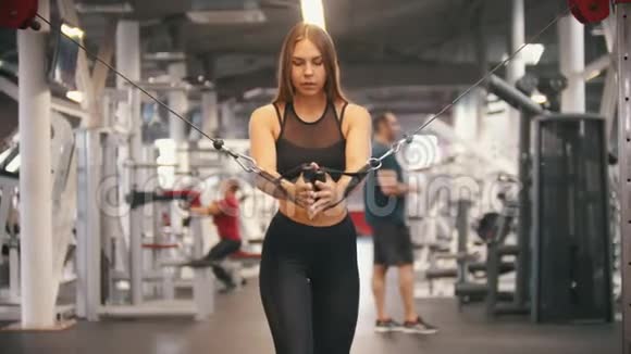 一名运动员女子在健身房训练拉手柄训练双手视频的预览图