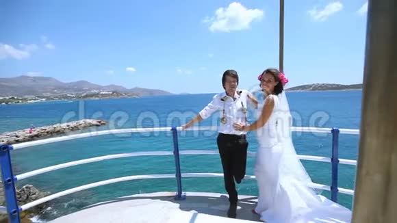 年轻漂亮的夫妇站在海边在他们的婚礼上拥抱视频的预览图
