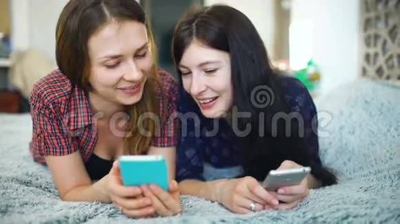 两个快乐的女性朋友用智能手机分享社交媒体聊天视频的预览图