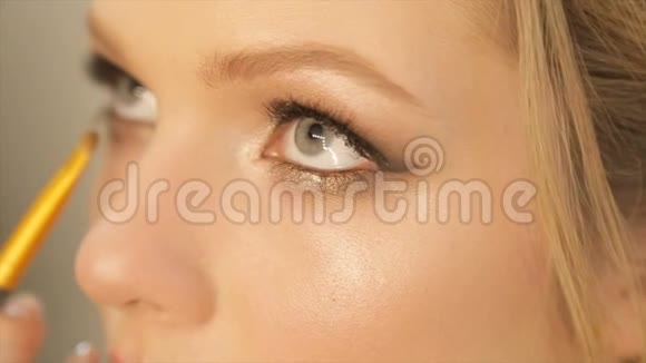 化妆师将明亮的基本彩色眼影涂在女孩的眼睛上视频的预览图