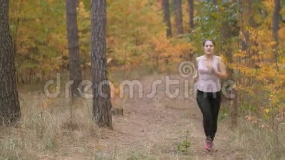 4k片年轻女子在森林里慢跑时休息片刻视频的预览图