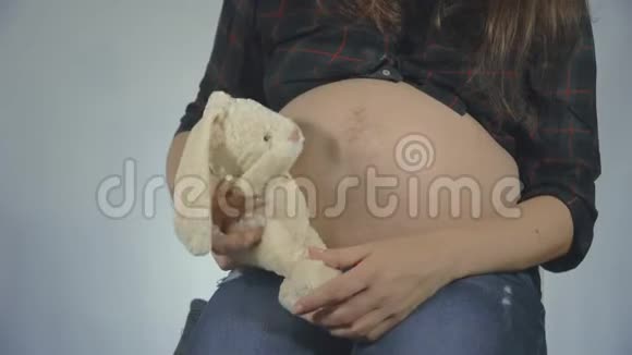 一位孕妇在玩长毛绒玩具摆姿势视频的预览图