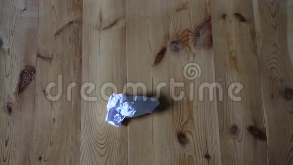 白色皱巴巴的纸落在木地板上视频的预览图