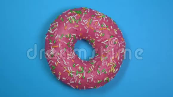 美味新鲜的甜甜圈特写镜头旋转在蓝色的背景视频的预览图