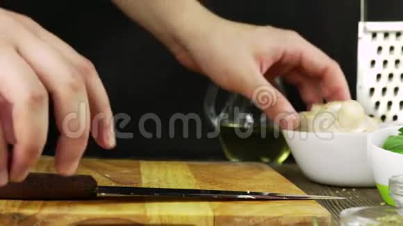 男人手在厨房里切蘑菇和巴黎香菜特写镜头视频的预览图