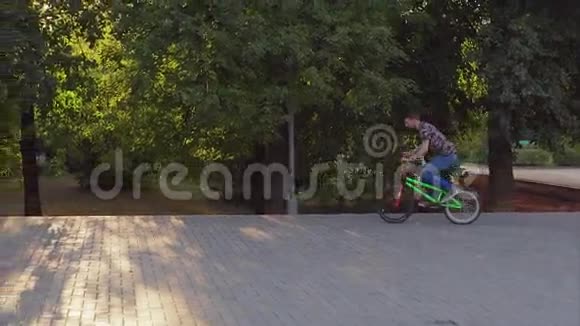 一个小男孩骑自行车在BMX公园里玩把戏视频的预览图