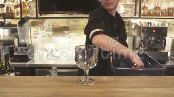 酒保拿着冰块鸡尾酒杯酒保准备酒精鸡尾酒快关门视频的预览图