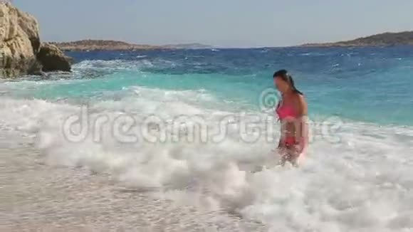 活跃的女人在阳光明媚的海边奔跑视频的预览图