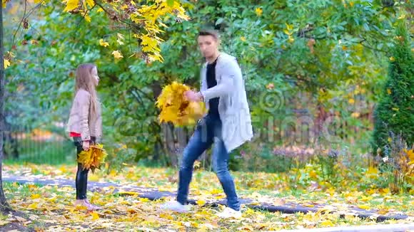 可爱的小女孩和快乐的父亲和母亲喜欢秋天在户外公园秋季家庭假期视频的预览图