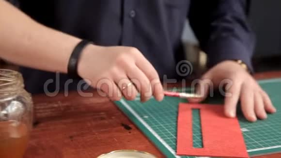 车间里的工匠在皮革坯布上涂胶制作皮革制品视频的预览图