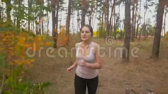 美丽的年轻女子在森林里慢跑短时间休息视频的预览图