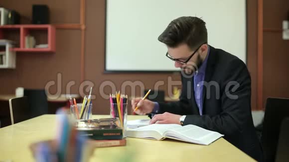 一个年轻人在学习重写一本笔记本视频的预览图