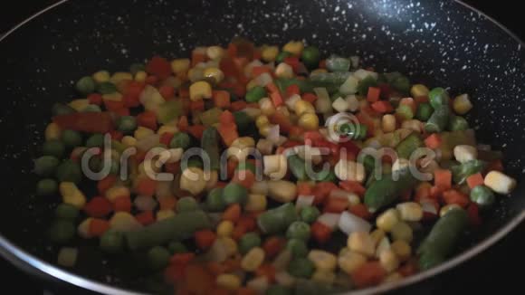 翻炒冷冻蔬菜用锅铲炒蔬菜把蔬菜拌在锅上健康烹饪视频的预览图