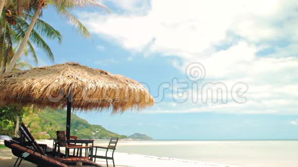 热带海滩草伞下的日光浴床视频的预览图