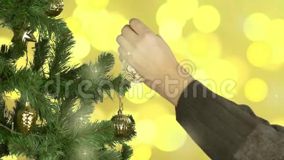 曼斯手装饰圣诞树金色灯光背景黄色球体球圈闪耀的光芒闪烁视频的预览图