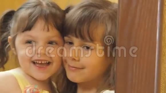 镜子前的孩子们姐妹们在拥抱镜子上的灰尘镜子前的小女孩视频的预览图