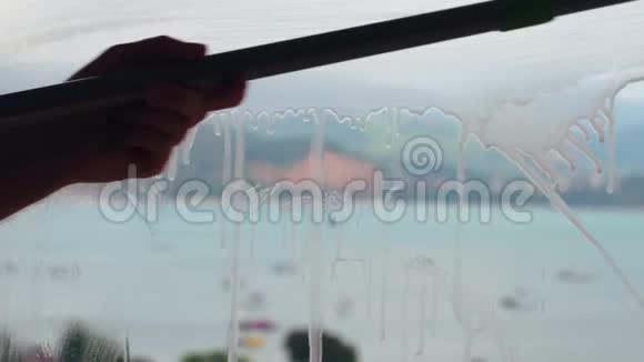 清洁工人用刮刀清洗和清洁窗户玻璃视频的预览图