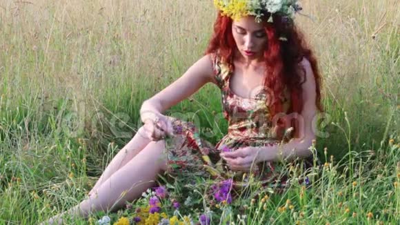 戴花环的漂亮女人坐在干草里夏天抚摸野花视频的预览图