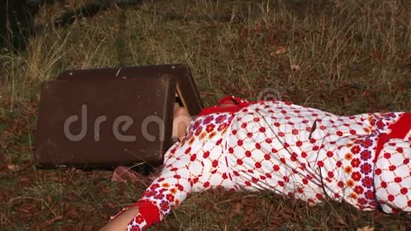 一个穿着白点长袍躺在草地上的奇怪女人视频的预览图