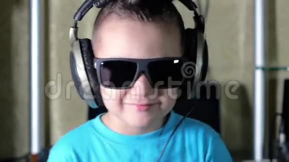 戴墨镜的男孩戴耳机听音乐视频的预览图