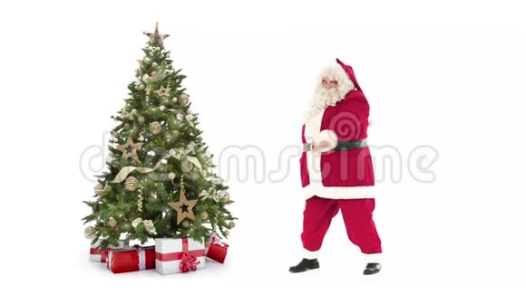 灯光装饰圣诞树礼品盒和圣诞老人快乐的舞蹈白色背景与文字空间放置视频的预览图