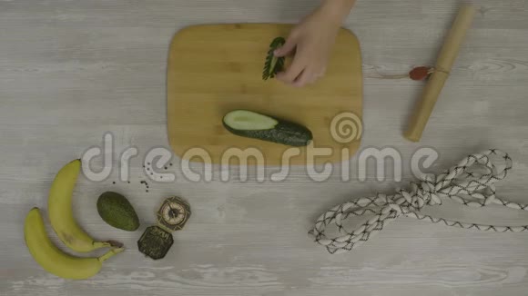 人手在木板上用刀切黄瓜桌子上有很多剪刀一把刀一把视频的预览图