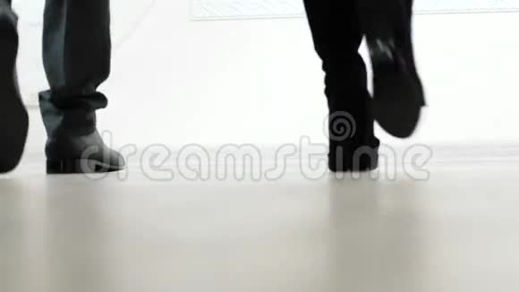 穿着皮鞋和靴子走路的男人和女人的腿视频的预览图