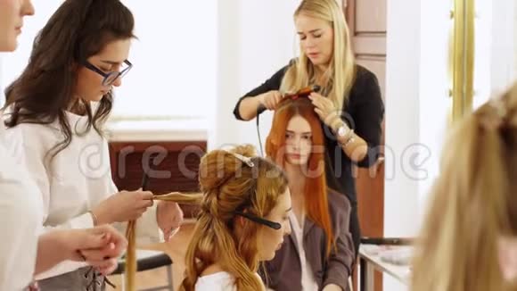 发型师的女人为模特的女孩做卷发师傅准备模型头发视频的预览图